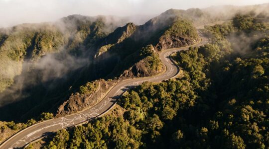 Vue aérienne de la route sinueuse du Maïdo à La Réunion avec virages en épingles et remparts volcaniques